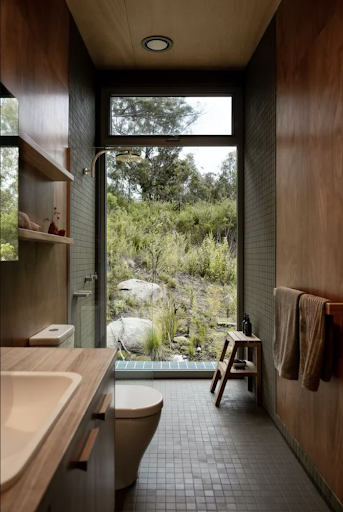 Interior of a ROAM-designed bathroom opening onto a hillside garden